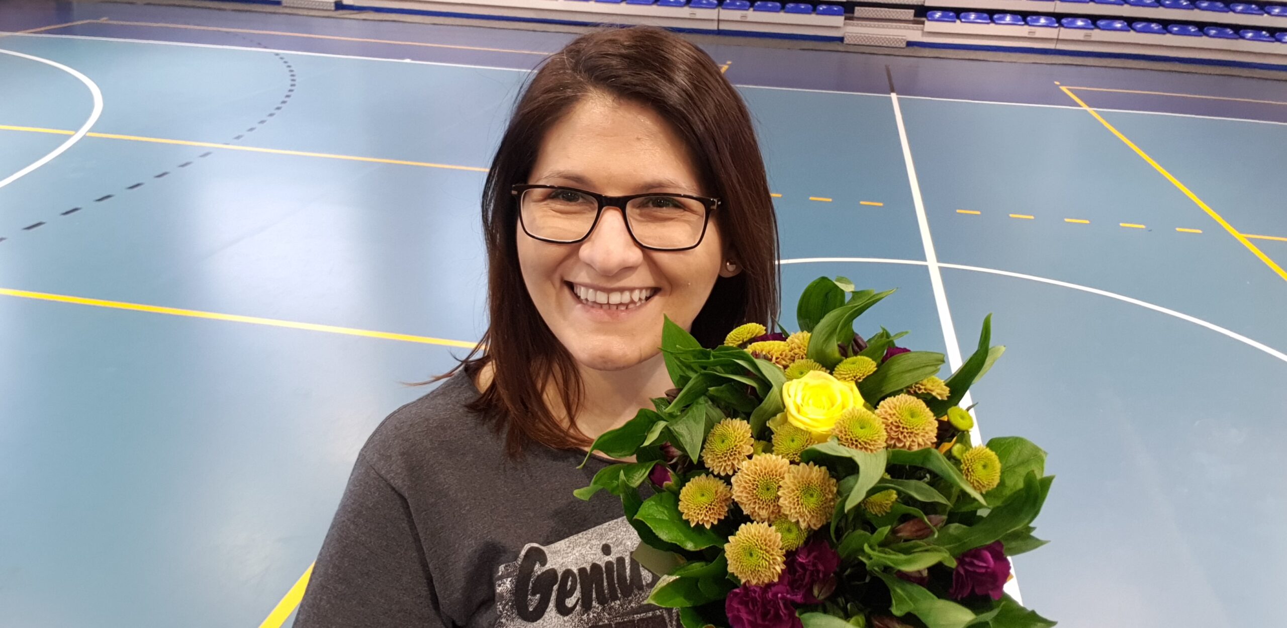 uśmiechnięta kobieta z kwiatami Warsztaty dla mazoretek i cheerleaderek w Lesznie