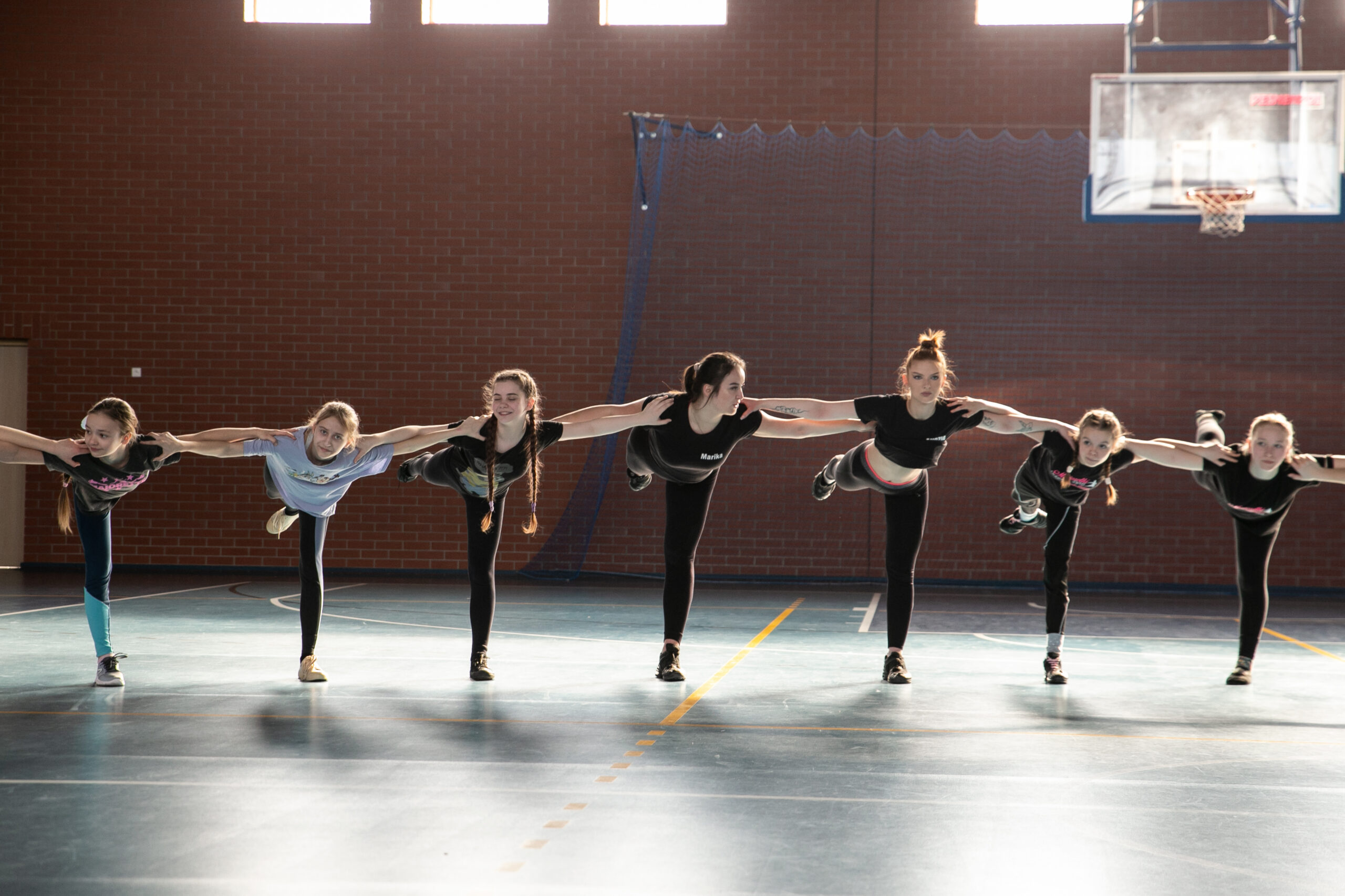 dziewczynki na sali gimnastycznej wykonujące ćwiczenie taneczne