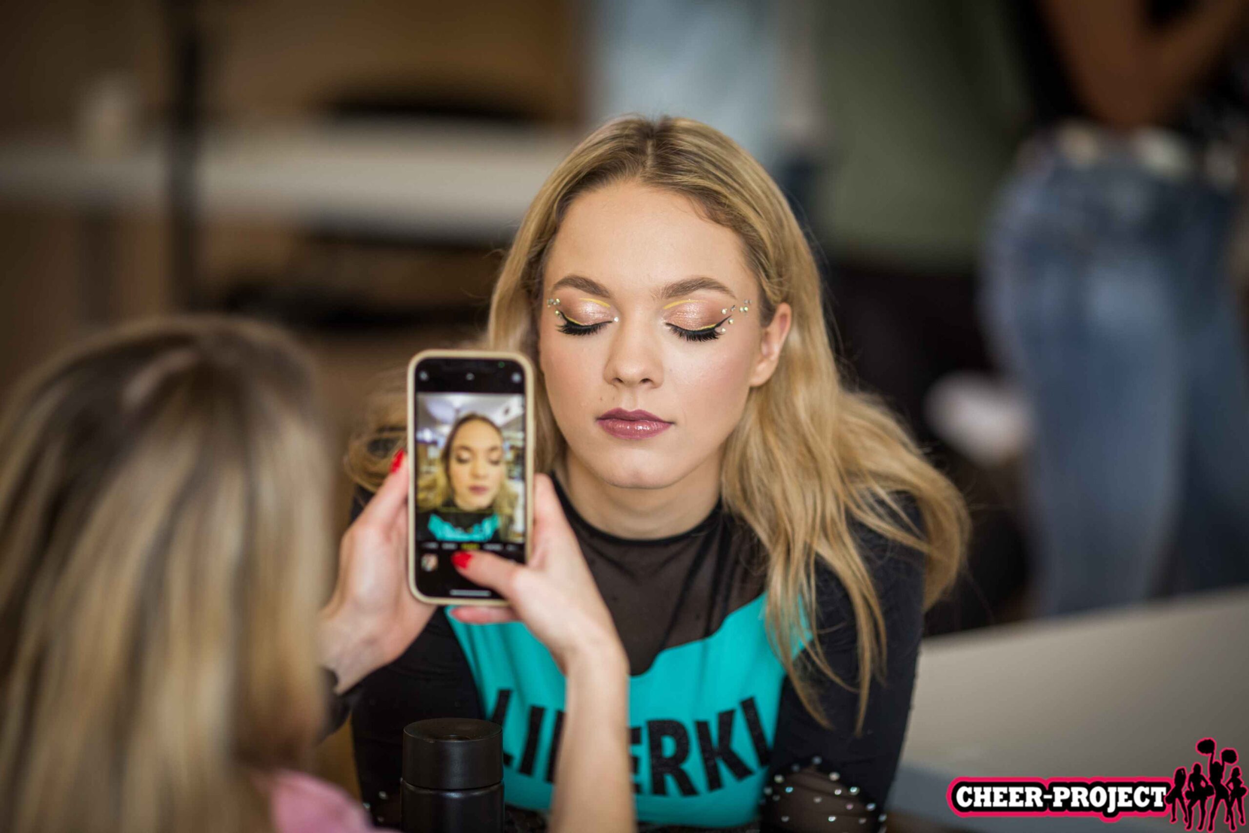 kobieta robi zdjęcie twarzy modelki telefonem