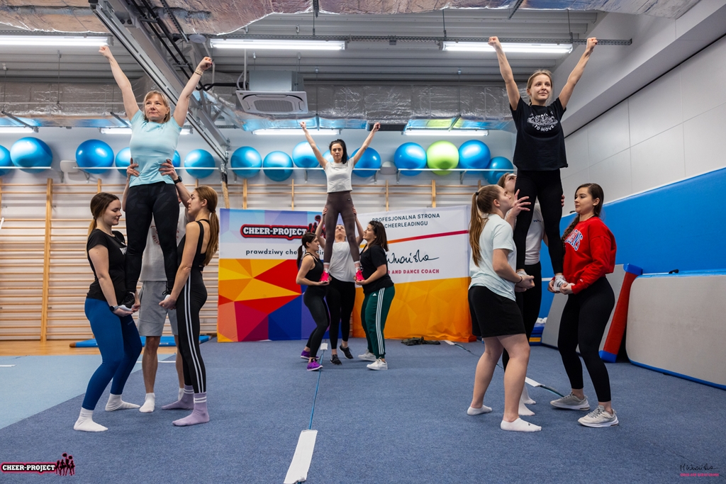 trzy stunty na poziomie bioder w wykonaniu uczestniczek kursu cheer acro basic z pomocą szkoleniowca Małgorzaty Wrońskiej