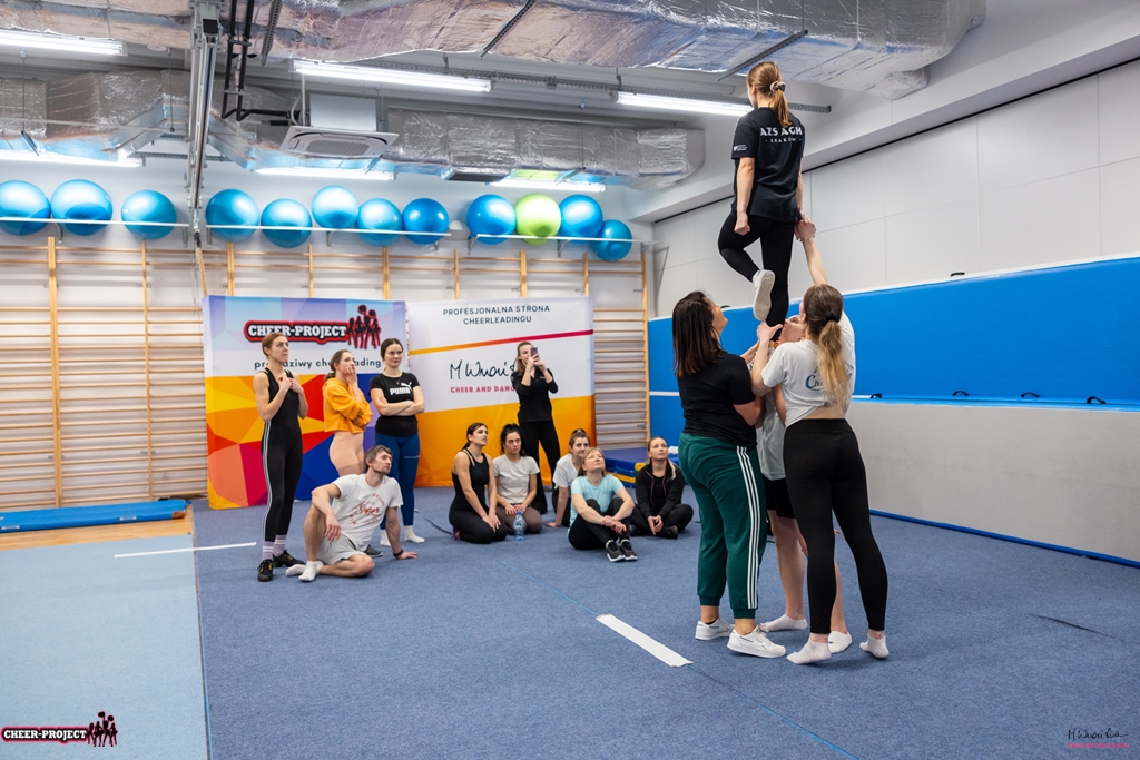 zaprezentowanie pozycji liberty na poziomie prep uczestnikom szkolenia wakacyjnego cheer acro basic